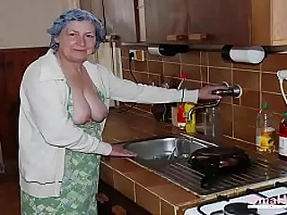 Elderly woman engages in sexual activity on bed, captivating and arousing.